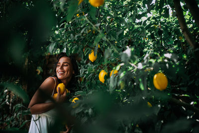 Smiling young woman against orange tree