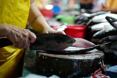 Close-up of hand preparing fish for sale