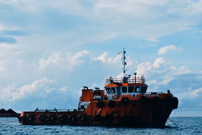 Ship sailing on sea against sky
