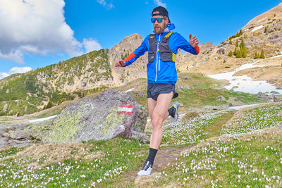 Full length of young woman standing on mountain