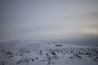 Snow covered landscape against sky