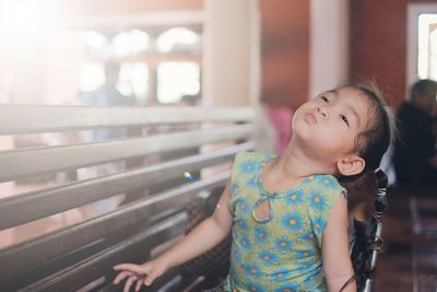 Cute girl looking away while playing at home