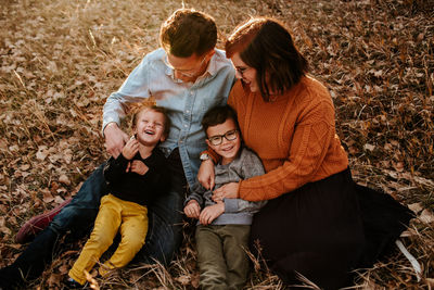 Happy young family sitting together on a fall evening