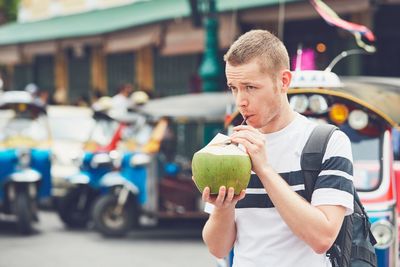 Man drinking coconut water on street