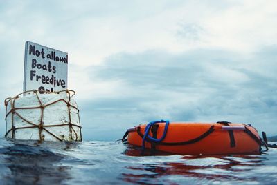 Information sign on sea against sky