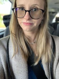 Portrait of young woman sitting in car