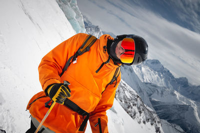 Portrait of a young adult in a ski helmet and goggles, with high