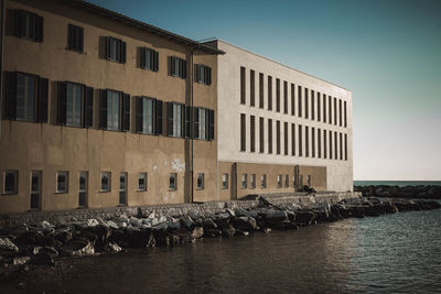 View of buildings by sea against clear sky