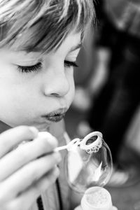 Close-up of boy blowing bubble outdoors