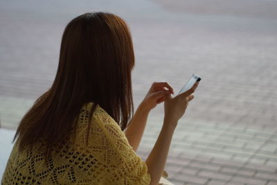 Rear view of woman using mobile phone