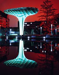 Reflection of illuminated building in water at night