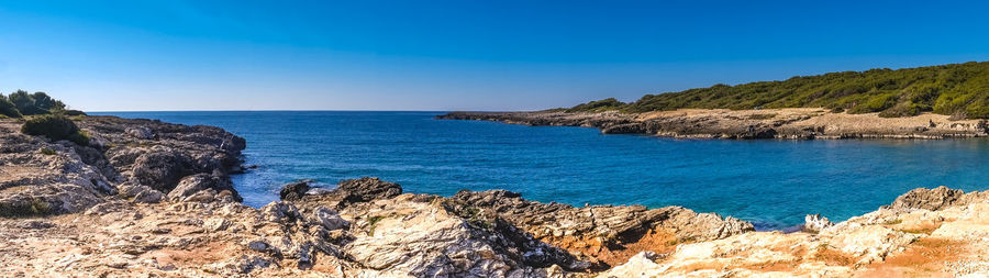 Panoramic view of sea against clear blue sky