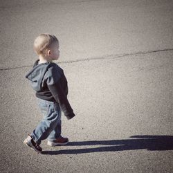 Full length side view of boy walking on footpath