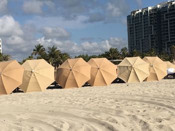 Umbrellas at sandy beach against sky