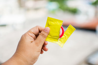 Close-up of man holding condom packet