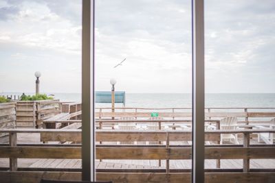 Sea against sky seen through window