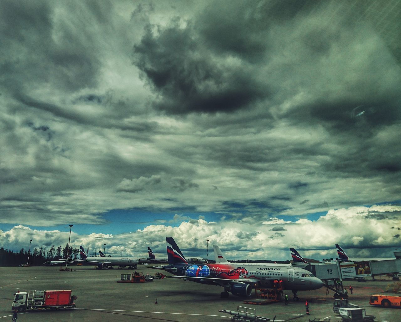 AIRPLANE ON AIRPORT RUNWAY AGAINST STORM CLOUDS