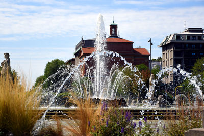 Water fountain against buildings in city