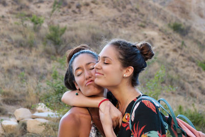 Young woman embracing friend outdoors