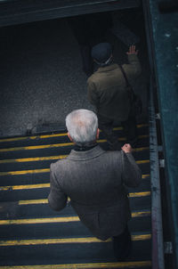 Rear view of people walking on street in city