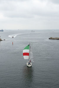 Sailboat sailing in sea against sky