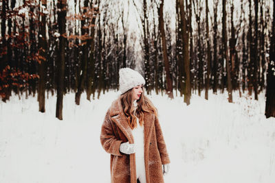 Rear view of woman standing in forest