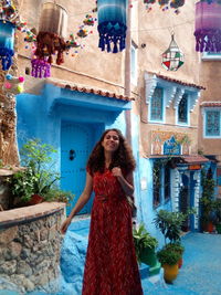 Portrait of smiling woman standing against building