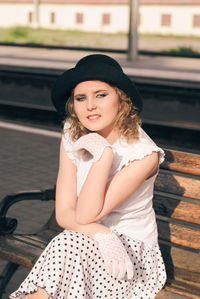 Portrait of beautiful young woman sitting outdoors