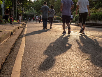 Rear view of people walking on road