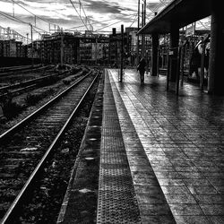 Railway tracks at railroad station against sky