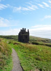 Old ruin on field against sky