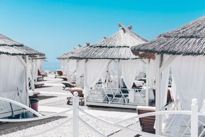 White gazebos with sofas on the beach for holidaymakers by the sea and ocean. 