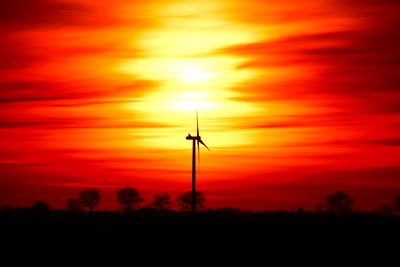 Silhouette of wind turbines during sunset