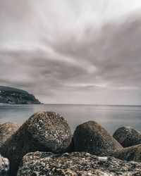 Rocks by sea against sky