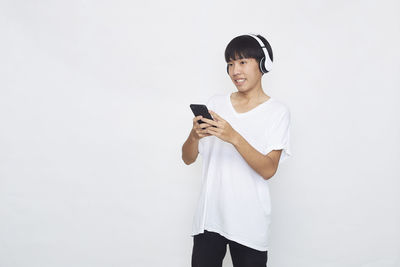 Young man using mobile phone against white background