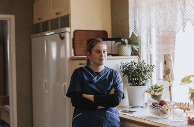 Home caretaker standing in kitchen