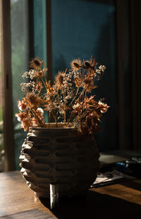 Backlited flowers in vase on the table in sunset time