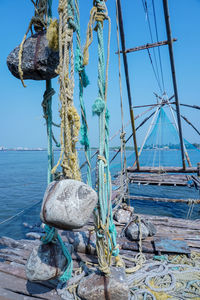 Rope tied to pole against blue sea