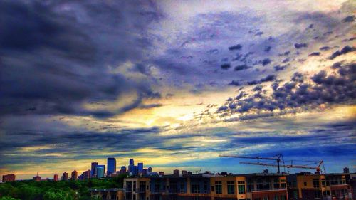 Buildings in city against cloudy sky