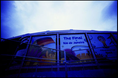 Low angle view of information sign against blue sky