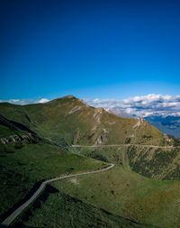 Scenic view of landscape and mountains against blue sky