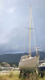 Boat moored on shore against sky