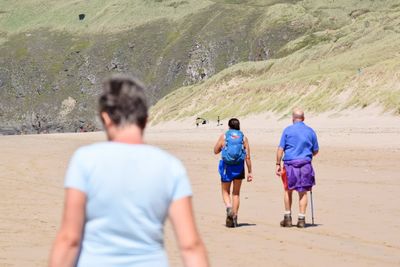 Rear view of people walking on land