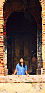 Close-up of woman looking away while standing at historic building