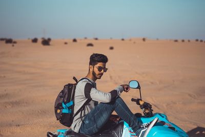 Full length of young man sitting on land