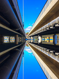 Low angle view of railway bridge against blue sky