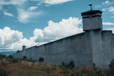 Low angle view of prison wall against sky