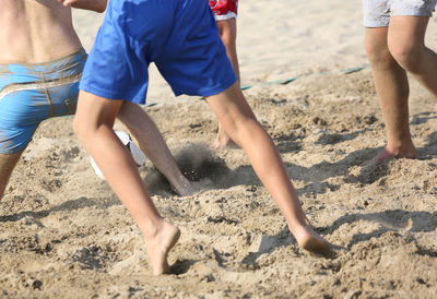 Low section of people playing on sand at beach