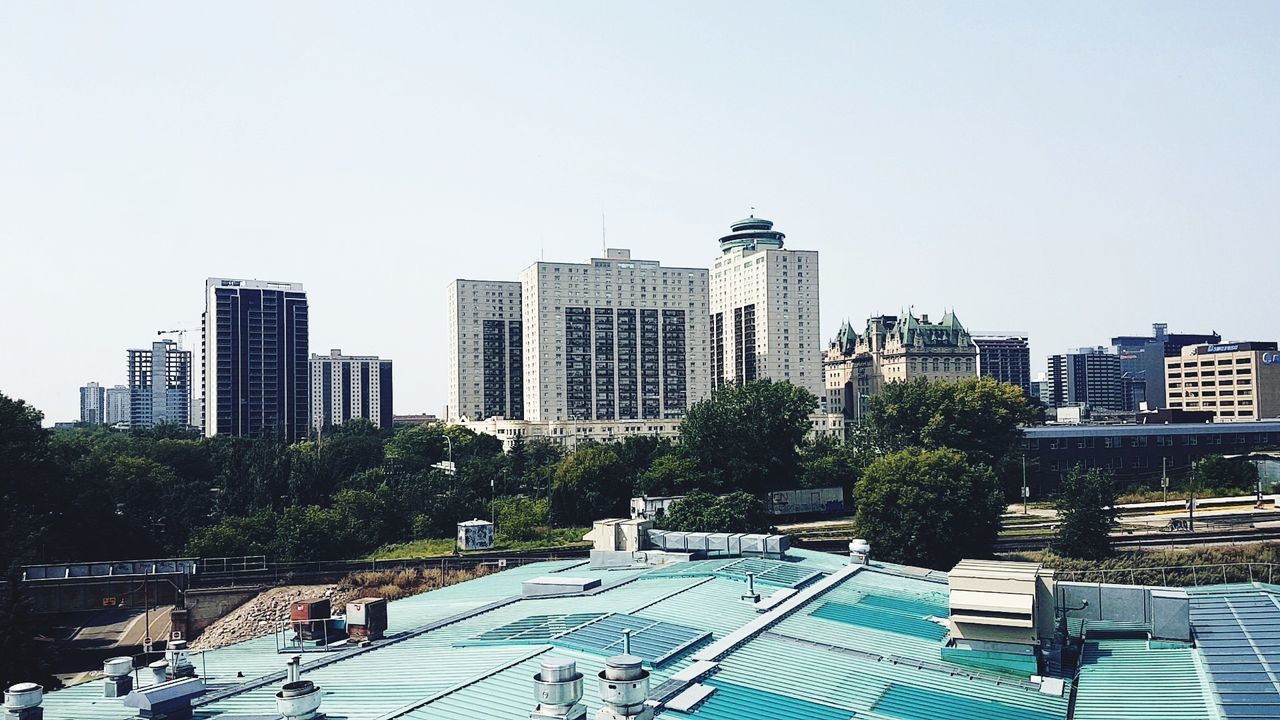 architecture, skyscraper, building exterior, built structure, city, tree, modern, copy space, cityscape, clear sky, day, water, growth, urban skyline, outdoors, swimming pool, sky, no people