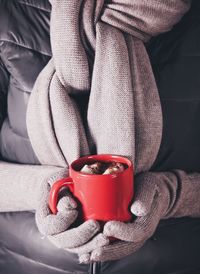 Close-up of hand holding red mug